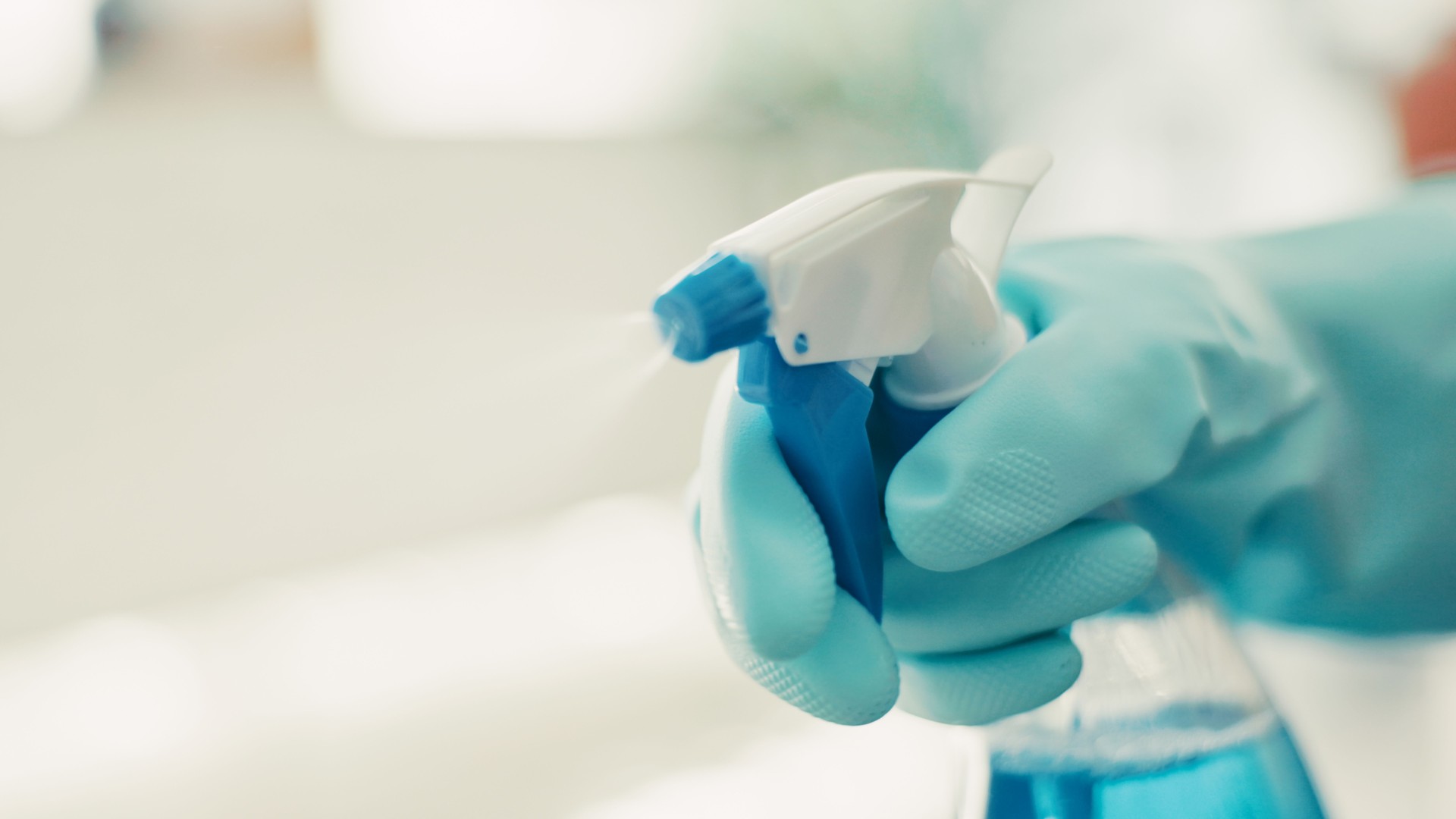 Gloves, cleaning and hand with disinfectant spray for housekeeping, bacteria removal or housework. Hygiene, person and chemical bottle in home for domestic chores, germ protection or virus sanitation